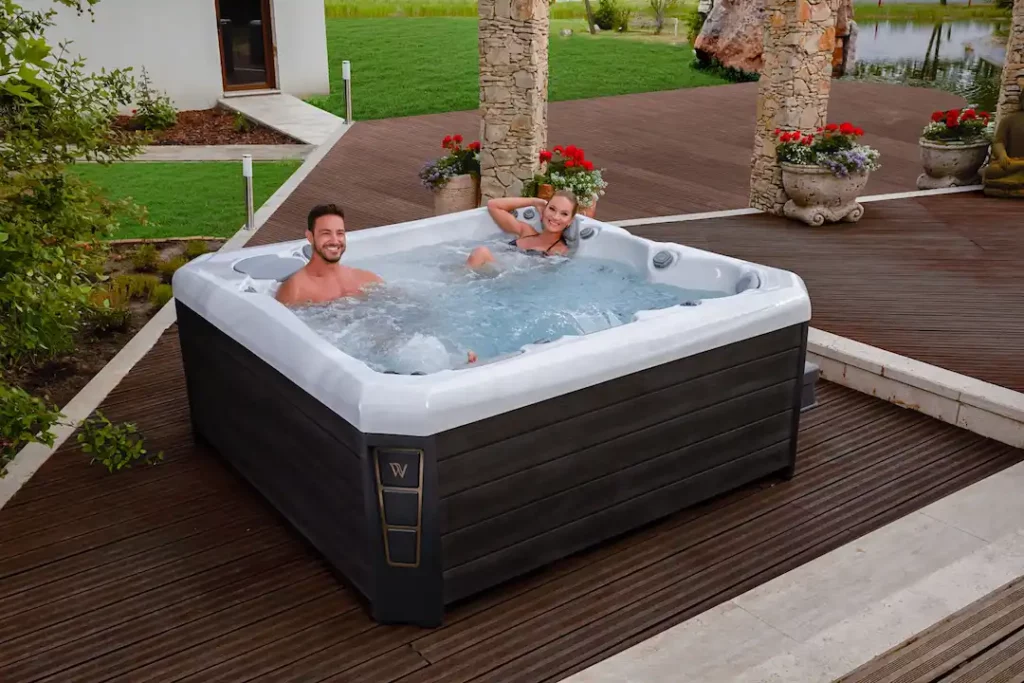 Picture of two people in a Wellis hot tub for the article the discusses how much does a hot tub cost?