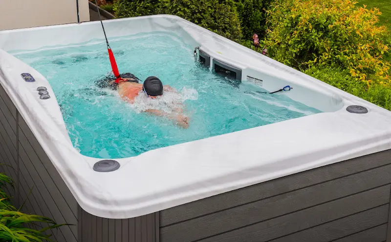 Person with a swim spa resistance band for their swim spa workout routine.